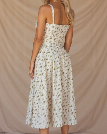 Back view of the white floral corset midi dress with green print, featuring a tie-back detail.
