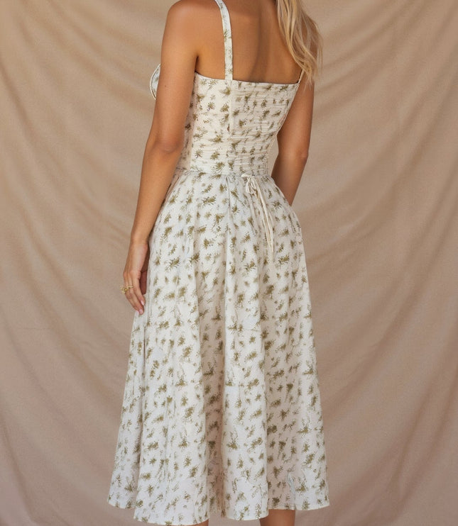 Back view of the white floral corset midi dress with green print, featuring a tie-back detail.