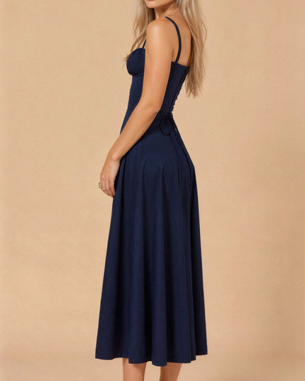 Side profile of a navy blue summer midi dress, highlighting the corset back and full skirt.