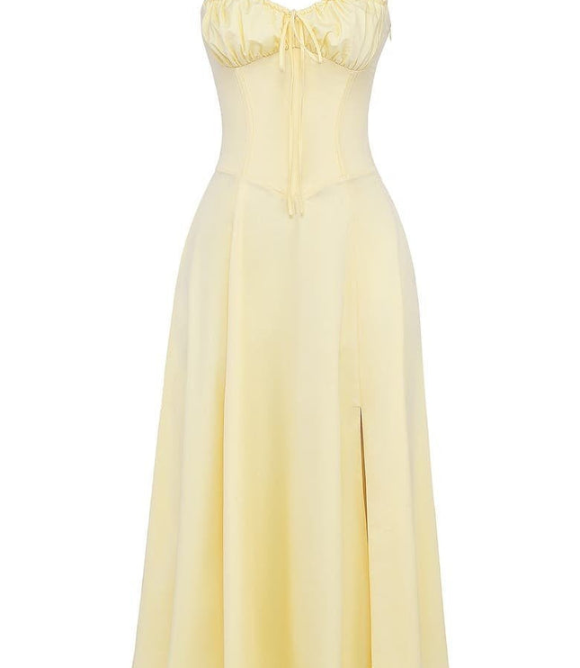 Light yellow summer corset midi dress featuring a ruched bow front bodice, thin straps, and a flowing skirt with a slit.