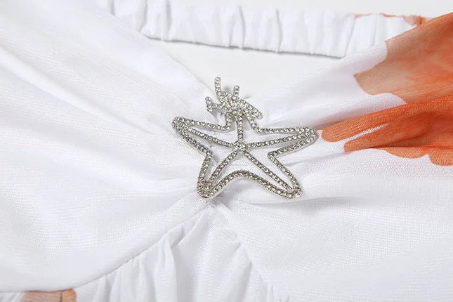 Close-up of the white summer floral ruffle mini dress bodice with a silver starfish embellishment and ruched detailing.