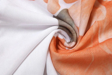 Fabric texture close-up of the white and orange floral print on the summer ruffle mini dress material.