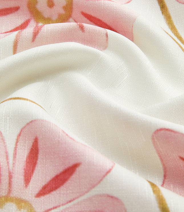 Detailed close-up of the white fabric with pink and gold floral print, highlighting the dress's pattern and material.