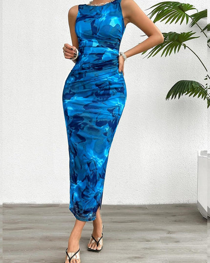 Sleeveless blue gradient print crew neck midi dress with ruched sides and a side slit, styled with black heels.