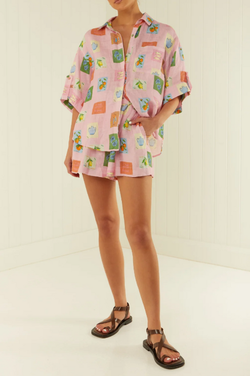 Full body shot of women's pink summer printed short sleeve short set with belt, styled with dark sandals.