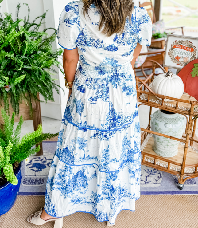 Back view of women's white summer maxi dress with blue scenic print, short sleeves, and smocked waist, with white block heels.