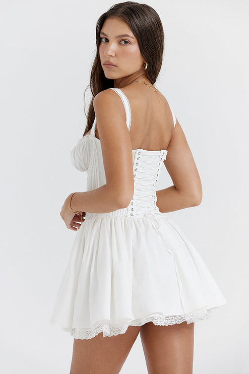 Back view of the white sweetheart neck mini dress, featuring a classic lace-up corset closure and ruffled straps.