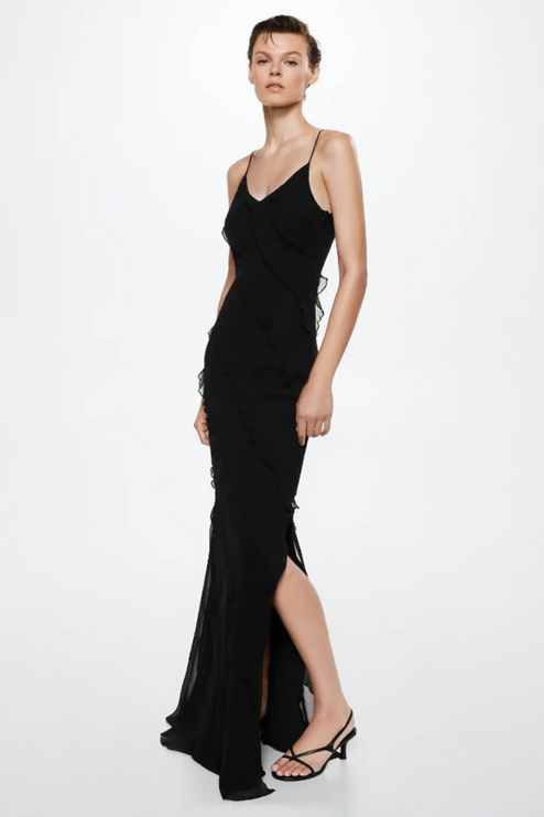Front view of a black V-neck ruffle side slit maxi dress with spaghetti straps and a side slit, worn with black heels