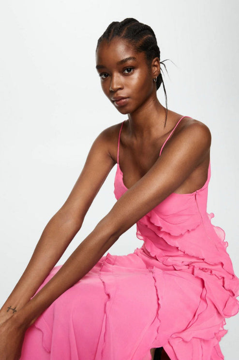 Seated view of the women's pink V-neck ruffle maxi dress, showcasing the flowing fabric and ruffles.