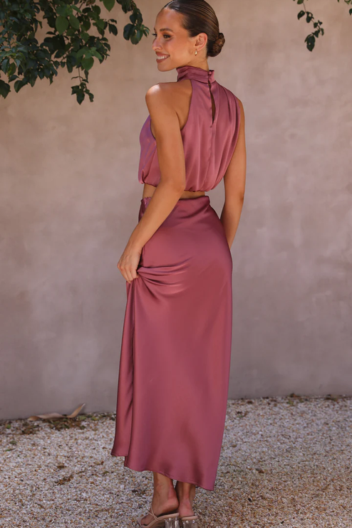 Back view of the plum satin two-piece maxi set, showing the high neck top with button closure and long skirt.