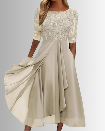Light beige boat neck midi dress with detailed lace overlay on the bodice and sheer elbow sleeves, paired with a soft, flowing chiffon skirt with pockets, suitable for wedding attire.