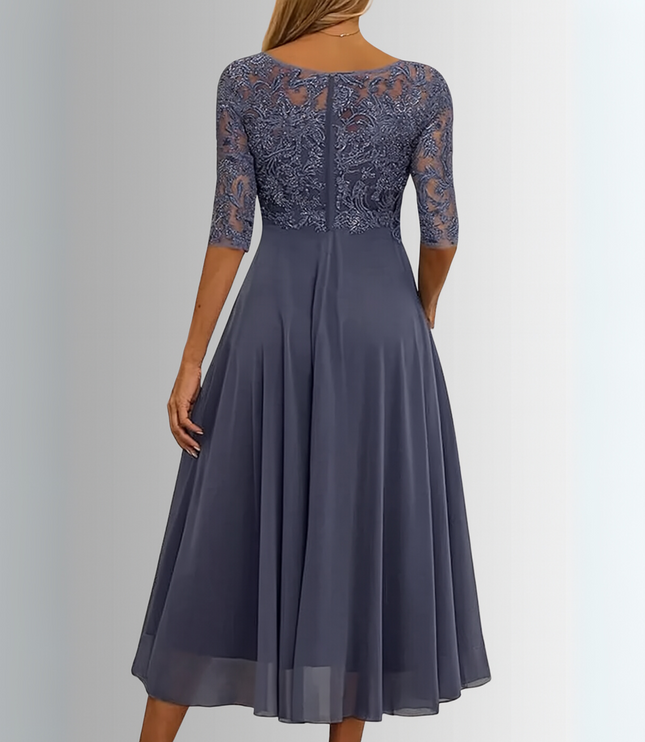 Back view of a women's dark grey boat neck midi dress, showing the elegant lace pattern on the bodice and sheer sleeves, with a smooth, flowing chiffon skirt.