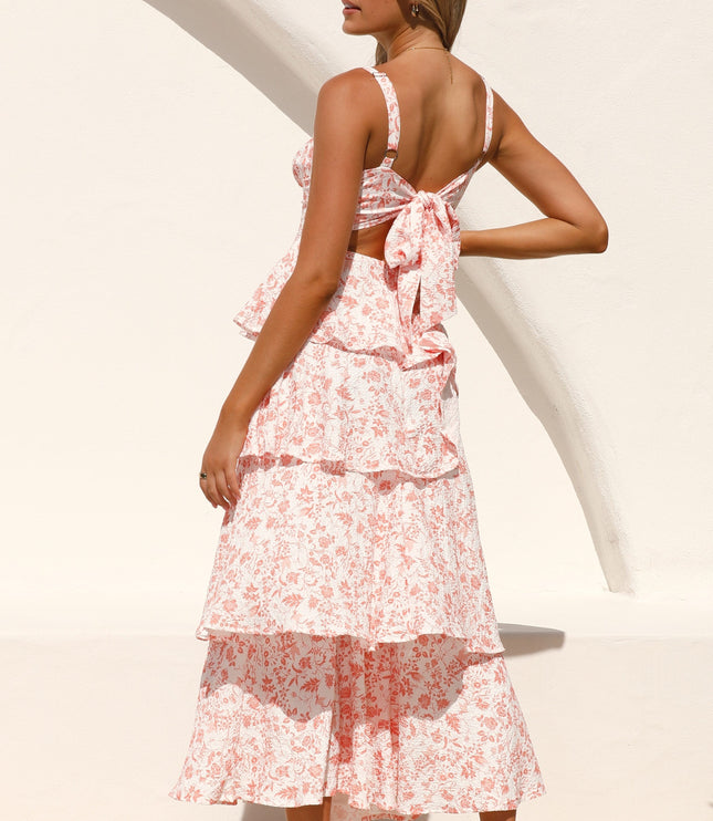 Back view of a woman wearing the pink floral ruffled maxi dress, showcasing the tie-back detail and tiered skirt.