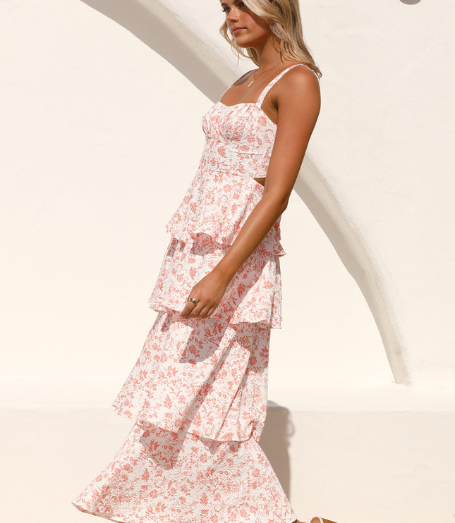 Side profile of a woman wearing the pink floral ruffled maxi dress, showing movement and flow of the tiered skirt.