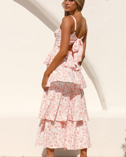 Rear view of the pink floral ruffled maxi dress, focusing on the open back with a large bow detail.