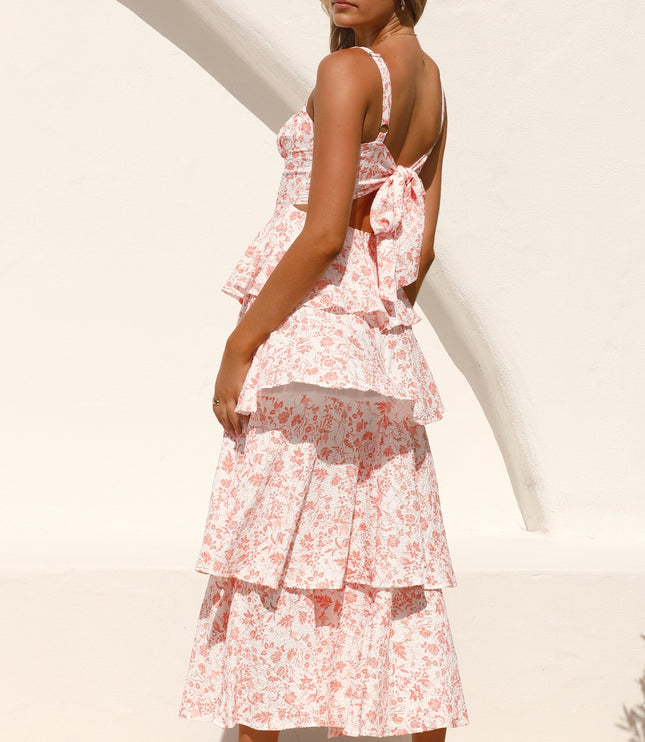 Rear view of the pink floral ruffled maxi dress, focusing on the open back with a large bow detail.
