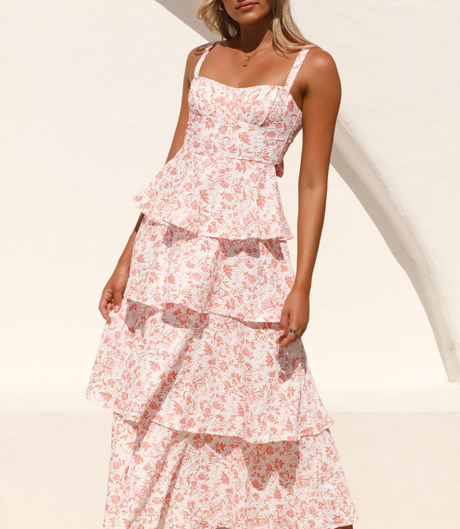 Front view of a woman wearing the pink floral ruffled maxi dress, showcasing the full length and tiered design.