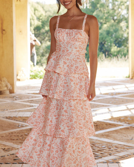 Full-length front view of a women's pink floral ruffled maxi dress, showcasing the flowing tiers.
