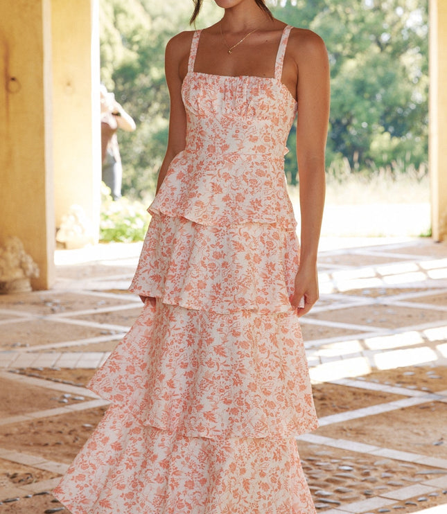 Full-length front view of a women's pink floral ruffled maxi dress, showcasing the flowing tiers.