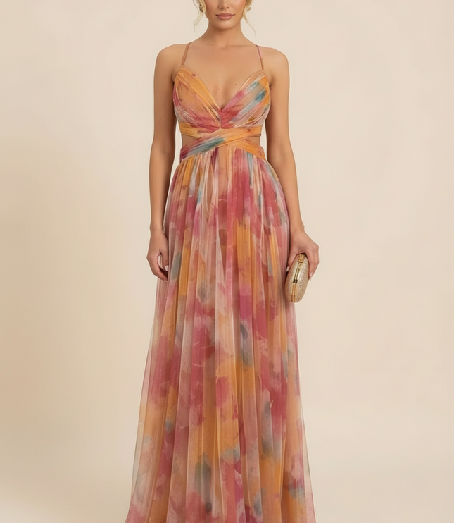 Women's wedding guest maxi dress with a colorful floral print, V-neck, and delicate spaghetti straps, holding a gold clutch.