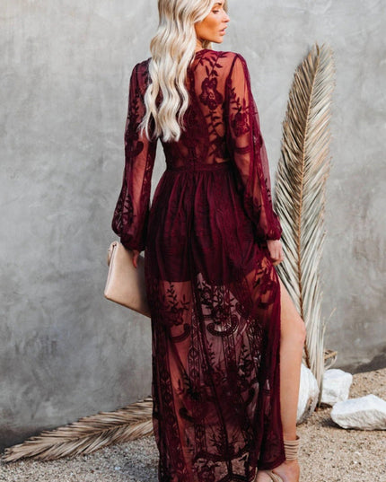 Back view of a women's deep burgundy lace long sleeve V-neck maxi dress, showcasing sheer skirt details.