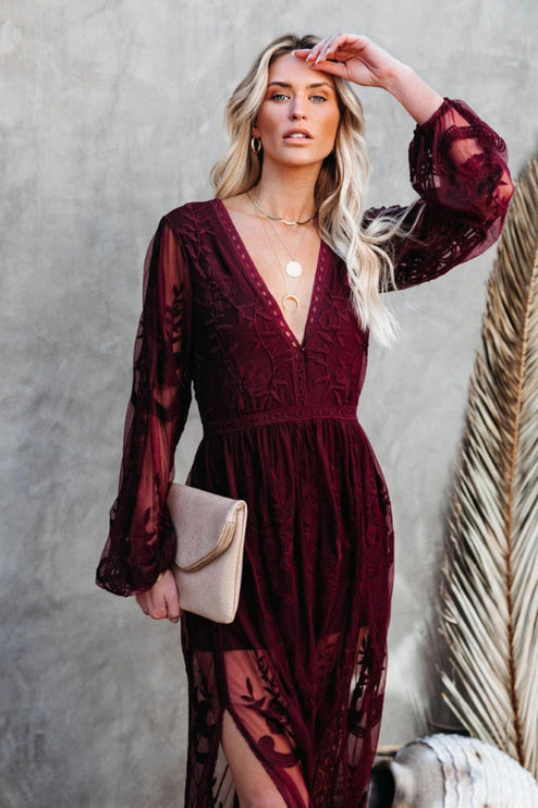 Close-up of a women's deep burgundy lace long sleeve V-neck maxi dress, highlighting the intricate lace pattern.