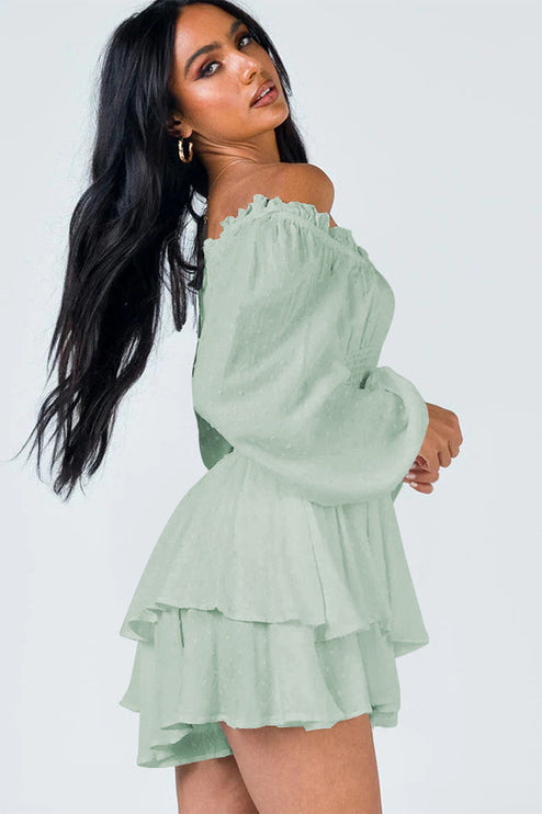 Side profile of a women's light green off-shoulder mini dress with textured fabric and tiered skirt detail.
