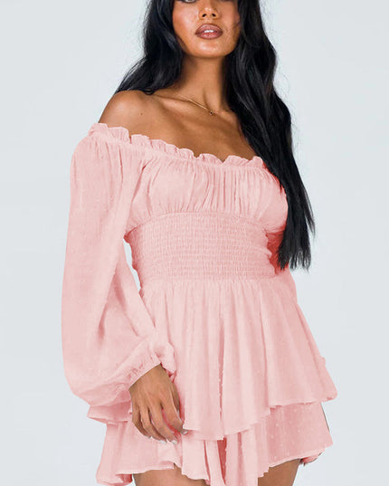 Close-up front view of a women's light pink off-shoulder mini dress with long sleeves, shirred bodice, and ruffled hem