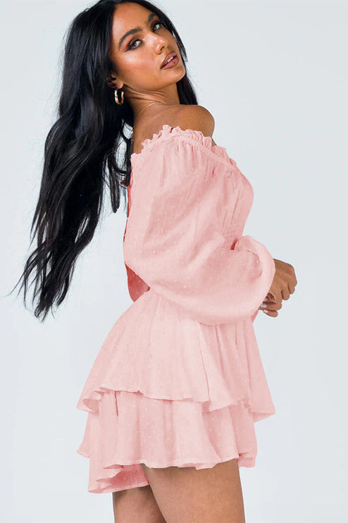 Side profile of a women's light pink off-shoulder long sleeve mini dress with a tiered ruffled skirt