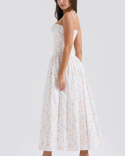 Side view of a white square neck sleeveless midi dress with delicate floral print and spaghetti straps, paired with pink heels.
