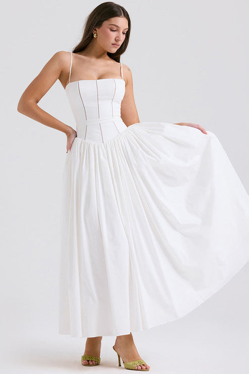Full view of women's white sleeveless midi dress, featuring a square neckline and flowing pleated skirt, with green heels.