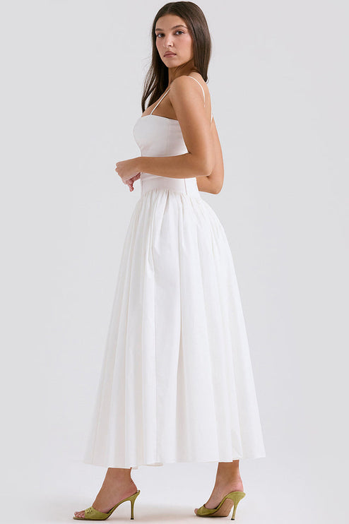 Side profile of women's white square neck midi dress, showing the structured bodice and voluminous skirt, with green heels.