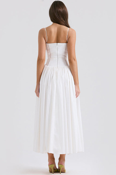 Back view of women's white square neck sleeveless midi dress, highlighting the fitted waist and pleated skirt, with green heels.