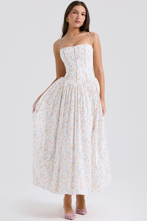 Women's white floral print square neck midi dress with delicate colorful flowers, structured bodice, and full skirt, with pink heels.
