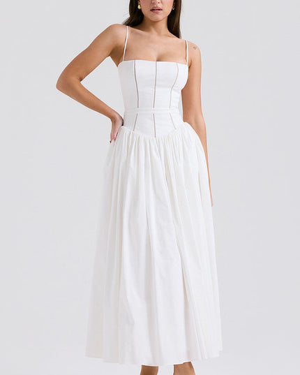 Women's white square neck midi dress with thin straps, structured bodice, and full pleated skirt, paired with green heels.