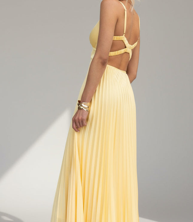 Three-quarter back view of the yellow pleated maxi dress, showing the criss-cross back straps and cut-outs.