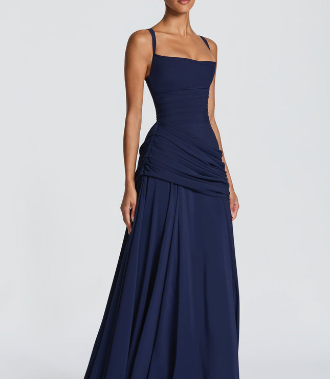 Navy satin maxi dress with square neck, ruched side drape, and full skirt, angled front view