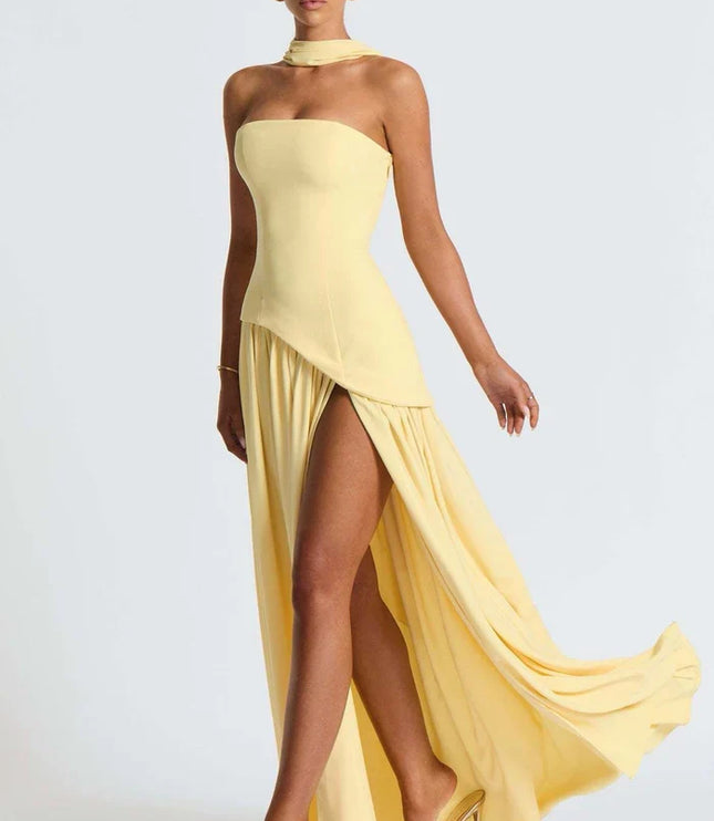 Pale yellow halter maxi dress with asymmetrical overlay, high slit, and flowing skirt front angle
