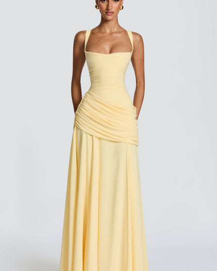 Pale yellow satin maxi dress with square neckline and side draped overlay, three-quarter front view