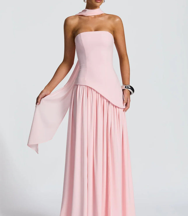 Back view of pink halter maxi dress with flowing skirt, fitted back, and soft scarf detail