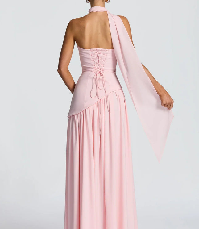 Back view of pink halter maxi dress with lace-up back, scarf tie, and long skirt